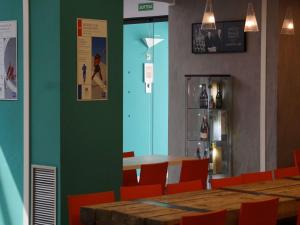 a dining room with a table and chairs and a green wall at Ibis Budget Girona Costa Brava in Girona