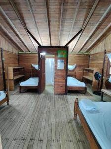 a room with two beds in a wooden cabin at Posada Don Aí in El Valle