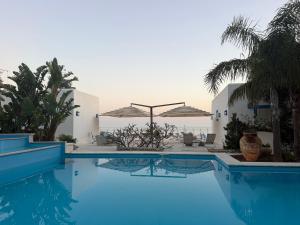 a swimming pool with umbrellas in a resort at Villa Mare Di Montelusa in Agrigento