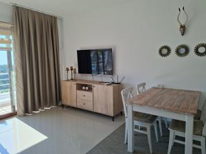 a living room with a table and a television on a cabinet at Sun Valley 2-bedroom apartment in Nicosia International Airport