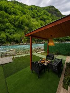a gazebo with two chairs and a table with food at Ayder River Suite by Karadeniz in Ardeşen