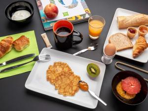 a table topped with plates of breakfast foods and drinks at ibis Styles Macon Centre in Mâcon