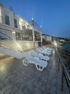 a row of lounge chairs on a balcony of a building at Villa Bakic in Dobra Voda