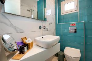 a bathroom with a sink and a toilet and a mirror at Margarita Fresh Studios in Potos