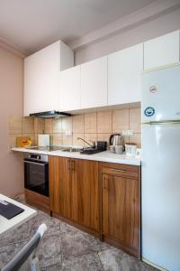 a kitchen with wooden cabinets and a white refrigerator at Margarita Fresh Studios in Potos