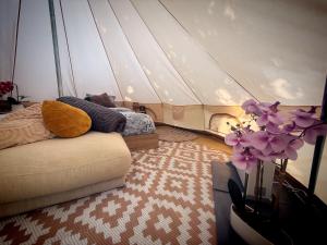 a room with a bed and a couch in a tent at La Clef des Ondes in Magescq