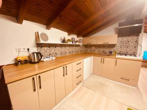 a kitchen with white cabinets and a wooden counter top at Ceres26 in Fethiye +23 photos