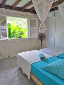 a bedroom with a bed and a window at Kazabat à Marie-Galante in Grand-Bourg