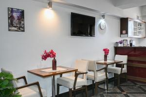 a restaurant with two tables and chairs and a tv at City5 ROOMS & SUITES by LSA in Skopje