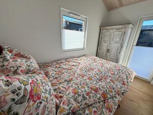a bedroom with a bed with a floral bedspread and a window at Weitblick- Sauna- WLAN- Haus 3 in Neheim-Hüsten