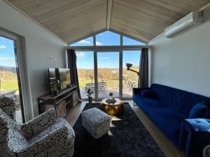 a living room with a blue couch and two chairs at Weitblick- Sauna- WLAN- Haus 3 in Neheim-Hüsten