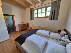 a bedroom with three beds and a window at Winklern Appartment Wildschütz in Kitzbühel
