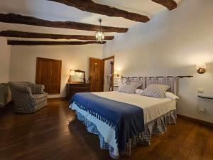 a bedroom with a large bed and a chair at Casona De La Salceda in Treceño