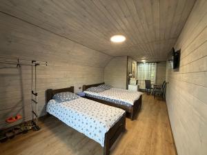 a bedroom with two beds in a room with wooden floors at Шепіт лісу in Bukovets +24 photos