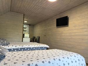 two beds in a room with a tv on the wall at Шепіт лісу in Bukovets