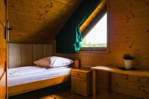 a small bedroom with a bed and a window at Domki u danusi in Stężyca