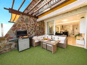 a patio with a grill and a table and chairs at Villa Gisel in La Playa de Tauro