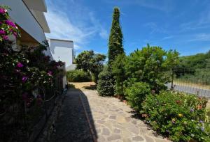 a garden with flowers and a building at Casa Iole in Budoni