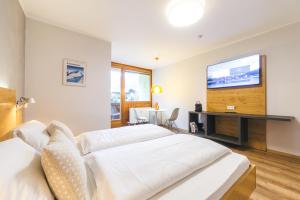 a bedroom with two beds and a flat screen tv at Studio 28 Kaprun inkl Sommerkarte in Kaprun