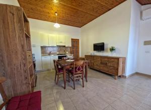 a kitchen and dining room with a wooden table and chairs at Casa Iole in Budoni