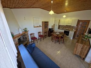 a living room with a blue couch and a kitchen at Casa Iole in Budoni