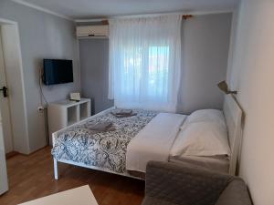 a small bedroom with a bed and a television at Apartmani Sidro in Privlaka +58 photos