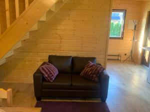 a leather couch in a room with a staircase at Domek letniskowy Remix in Zwierzyniec