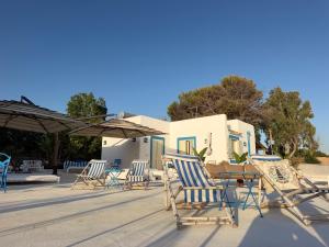 a group of chairs and tables on a patio at Villa Mare Di Montelusa in Agrigento