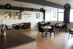 um restaurante com mesas e cadeiras num quarto em Vildbjerg Sports Hotel & Kulturcenter em Vildbjerg