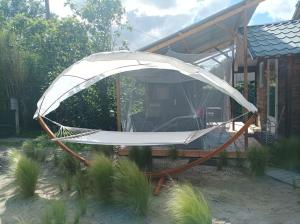a white hammock in front of a house at Tiny house tout inclus in Fronton