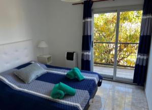 a bedroom with a bed with two green pillows on it at Departamentos en Chivilcoy in Chivilcoy