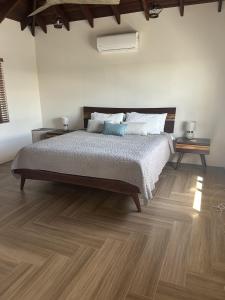 a bedroom with a bed and wooden floors at The Cottage in Saint Georgeʼs