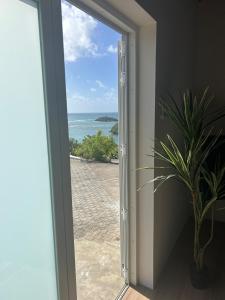 a sliding glass door with a view of the ocean at The Cottage in Saint Georgeʼs +7 photos