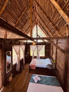 a bedroom with two beds in a straw hut at Nawala Eco-hostel in Termales - agua caliente - nuqui