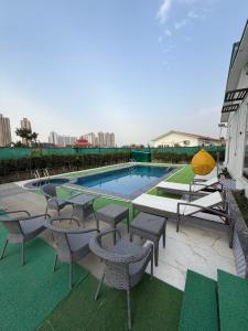 a swimming pool with tables and chairs on a building at oliv Faram house in Greater Noida