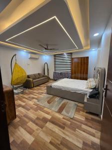 a bedroom with a bed and a couch in it at oliv Faram house in Greater Noida
