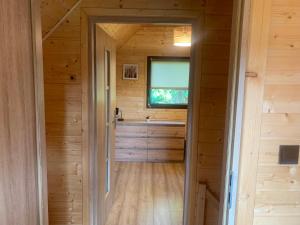 a bathroom in a log cabin with a window at Domek letniskowy Remix in Zwierzyniec +2 photos