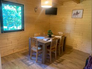 a wooden dining room with a table and chairs at Domek letniskowy Remix in Zwierzyniec