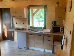 a kitchen with a counter with a microwave and a sink at Domek letniskowy Remix in Zwierzyniec
