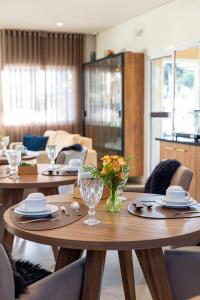 a dining room with two tables with plates and glasses at Ti Voglio Bene in Campos do Jordão
