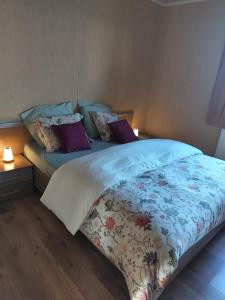 a bedroom with a large bed with purple pillows at Brouckmolen in Alveringem