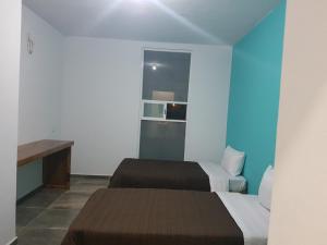 Cette chambre comprend deux lits et un bureau. dans l'établissement La Siesta del Patron, à Querétaro
