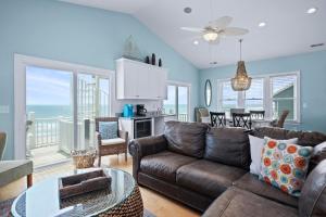 a living room with a couch and a table at Sea La Vie by Emerald Isle Realty in Emerald Isle