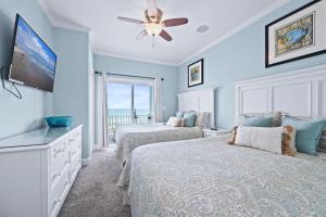 a bedroom with two beds and a flat screen tv at Sea La Vie by Emerald Isle Realty in Emerald Isle +128 photos