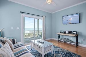 a living room with a couch and a table at Sea La Vie by Emerald Isle Realty in Emerald Isle