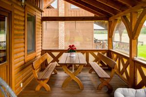 a wooden porch with a table and two chairs at Domki u danusi in Stężyca