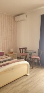 a bedroom with a bed and a table and chairs at Studio à la campagne in Villanova