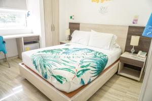 a bedroom with a bed with a blue and white blanket at Hotel Sixtina Plaza Medellin in Medellín