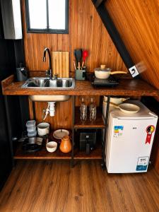 a small kitchen with a sink and a refrigerator at Chalé Suiço Diniz e Ferreira in Contagem