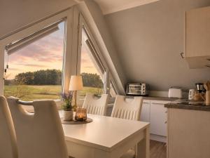 a kitchen with a table and chairs and a window at Ferienhaus Am Achterwasser in Ueckeritz +70 photos